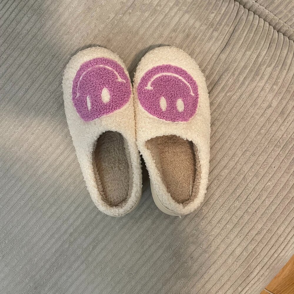 Fluffy white slippers with purple smiley faces